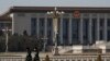 FILE - Paramilitary policemen wearing protective face masks are seen walking in an empty Tiananmen Square against the backdrop of the Great Hall of the People in Beijing, China, Feb. 23, 2020.