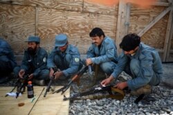 FILE - Members of the Afghan Police clean their rifles during a weapons maintenance training session at Narizah base in Narizah, Khost Province, Aug. 12, 2012.