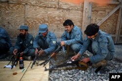 FILE - Members of the Afghan Police clean their rifles during a weapons maintenance training session at Narizah base in Narizah, Khost Province, Aug. 12, 2012.