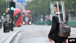 Seorang pejalan kaki mengenakan pelindung wajah di tengah pandemi Covid-19 di London, Inggris, 11 JUni 2020. (Foto: dok). 