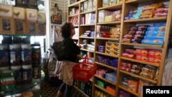 FILE - Paula Jarvis, 61, buys biscuits at the King's Head pub in Santa Monica, California, May 6, 2021. Prices Americans pay for goods and services are rising at the fastest rate in more than a decade.