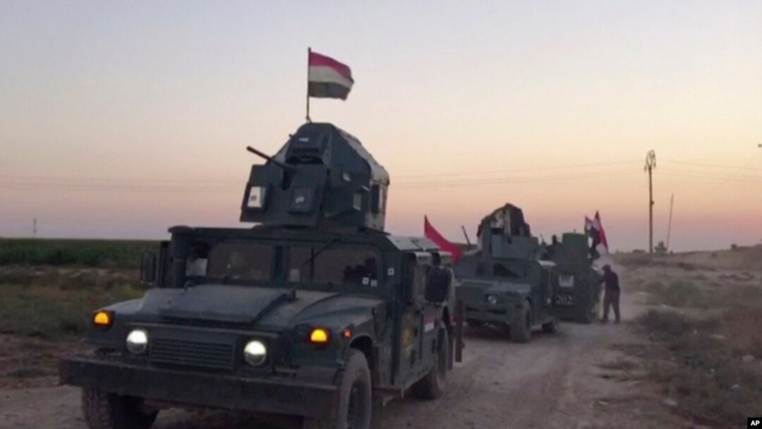 Gambar dari rekaman video memperlihatkan tentara Irak mengendarai kendaraan militer di wilayah Qatash menuju kilang gas Kirkuk, 16 Oktober 2017.