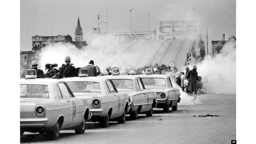 FILE - Clouds of tear gas fill the air as state troopers, ordered by Gov. George Wallace, break up a demonstration march in Selma, Ala., March 7, 1965, on what became known as "Bloody Sunday."