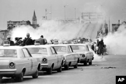 FILE - Clouds of tear gas fill the air as state troopers, ordered by Gov. George Wallace, break up a demonstration march in Selma, Ala., March 7, 1965, on what became known as "Bloody Sunday."