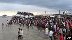 Warga berkumpul di tepi sungai Padma setelah sebuah feri terbalik di distrik Munshiganj, Bangladesh, 4 Agustus 2014.