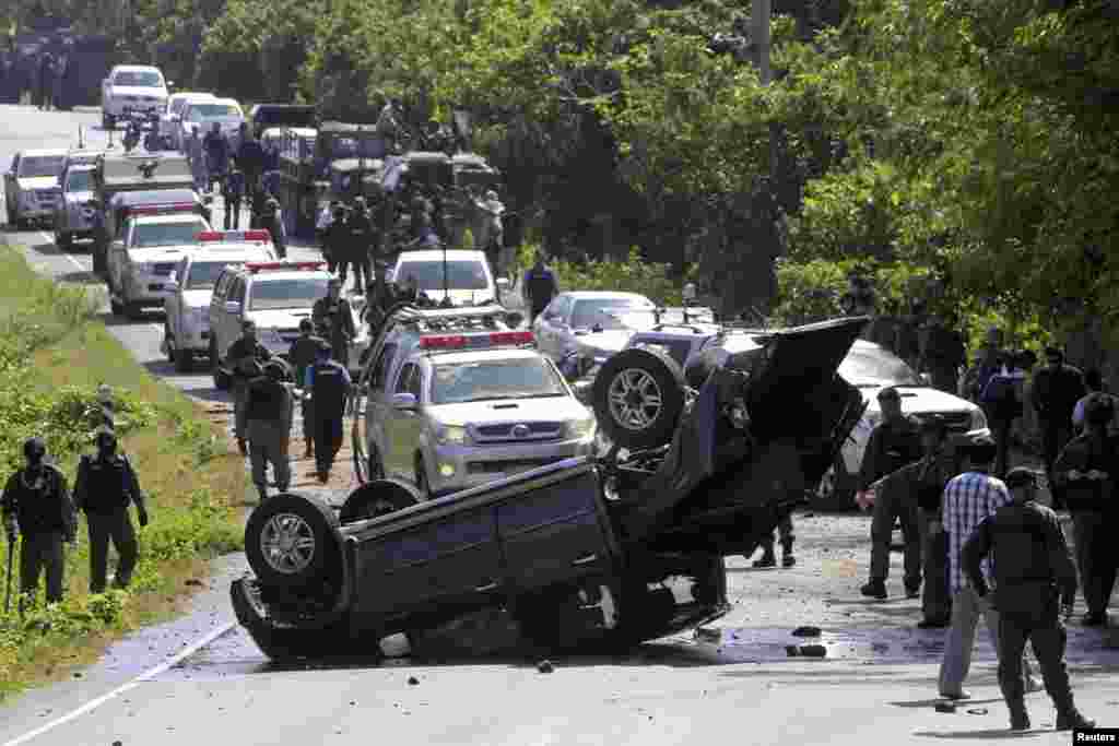 Two policemen were killed and three wounded in a roadside bomb attack as they were traveling to provide security to polling stations for Sunday&#39;s Senate elections. Here security forces inspect the site of a bomb attack on police in the troubled southern Thai province of Narathiwat, March 30, 2014. &nbsp;