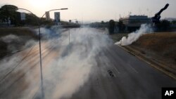 Tear gas covers an empty highway next to La Carlota air base in Caracas, Venezuela, Tuesday, April 30, 2019.(AP Photo/Ariana Cubillos)