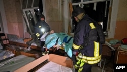 Ukrainian rescuers evacuate a man from a hospital following a drone attack in Kharkiv early on March 1, 2025, amid the Russian invasion of Ukraine.