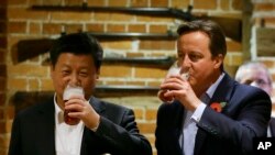 Presiden China Xi Jinping (kiri) bersama Perdana Menteri Inggris David Cameron (kanan) di Inggris, Kamis, 22 Oktober 2015. (AP Photo/Kirsty Wigglesworth)