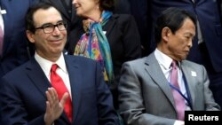 U.S. Treasury Secretary Steve Mnuchin waves next to Japan's Deputy Prime Minister and Finance Minister Taro Aso at the International Monetary Fund Governors family photo during the IMF/World Bank spring meeting in Washington, April 21, 2018.