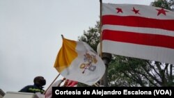 Un trabajador municipal coloca banderas del Vaticano, EE.UU. y el Distrito de Columbia en la avenida Pennsylvania por donde pasará la caravana papal.