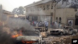 Sebuah mobil nampak terbakar di lokasi ledakan bom di gereja katolik St.Theresa di Madalla, dekat ibukota Abuja, Nigeria, menewaskan sedikitnya 27 orang pada perayaan Natal tahun lalu (Foto: dok). Serangan Malam Natal di Nigeria kembali terjadi tahun ini di luar kota Potiskum, negara bagian Yobe, meneewaskan sedikitnya eman orang.