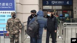 2020年1月23日安保人员在武汉市汉口火车站入口处检查人员。