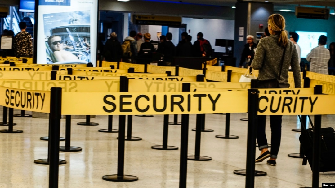 Para penumpang sedang berjalan menuju pemeriksaan keamanan di Bandara Internasional JFK di New York.