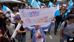 Una mujer sostiene un cartel durante una marcha contra las acciones legales emprendidas por la Fiscalía General contra el partido Movimiento Semilla y el presidente electo Bernardo Arévalo en Ciudad de Guatemala, el 2 de septiembre de 2023.