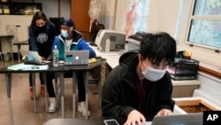 FILE - Students navigate an online lesson with the help of an instructor, at West Brooklyn Community High School in New York City, Oct. 29, 2020. 