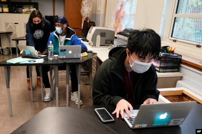 FILE - Students navigate an online lesson with the help of an instructor, at West Brooklyn Community High School in New York City, Oct. 29, 2020.
