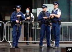 Police stand outside Christchurch High Court as family and survivors from the March 2019 Christchurch mosque shootings arrive for the sentencing of 29-year-old Australian Brenton Harrison Tarrant, in Christchurch, New Zealand, Aug. 24, 2020.