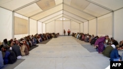 Afghan refugees eat lunch at a registration center upon their arrival from Pakistan at the Afghanistan-Pakistan border in Spin Boldak district of Kandahar province on Dec. 3, 2023.