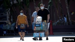 FILE - Shoppers wearing face masks are pictured outside a Walmart Superstore during the coronavirus pandemic, in Rosemead, California, June 11, 2020.