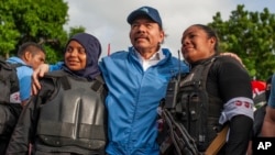 ARCHIVO - La policía de Nicaragua se toma una foto con el presidente Daniel Ortega, en Masaya, Nicaragua, el viernes 13 de julio de 2018. Foto AP/Archivo Cristóbal Venegas