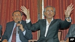 French philosopher Bernard-Henri Levy (R) and Suleiman Fortia, Misrata TNC member, speak during a news conference after lobbying French President Sarkozy for weapons supplies, in Paris, July 20, 2011