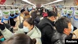 2022年12月26日的上班早高峰，北京的地铁车厢挤满了乘客。