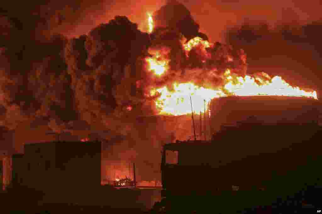 Oil tanks burn at the port in Hodeidah, Yemen, July 20, 2024. The Israeli army said it has struck several Houthi targets in western Yemen following a fatal drone attack by the rebel group in Tel Aviv the previous day.&nbsp;