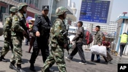 ARSIP – Anggota paramiliter bersenjata kepolisian China berbaris melalui lokasi ledakan di luar Stasiun Kereta Api Urumqi bagian Selatan di Urumqi yang terletak di Daerah Otonomi Uighur Xinjiang China, 1 Mei 2014.