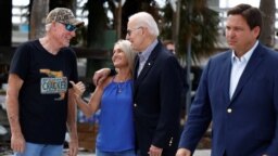 Presiden AS Joe Biden, ditemani oleh Gubernur Florida Ron DeSantis (kanan), berbincang dengan sejumlah warga yang terdampak badai Ian di Florida dalam kunjungannya ke wilayah Fort Myers Beach, Florida, pada 5 Oktober 2022. (Foto: Reuters/Evelyn Hockstein)