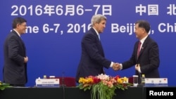 Menlu AS John Kerry berjabat tangan dengan wakil Perdana Menteri China, Wang Yang dalam dialog AS-China di Beijing (7/6).