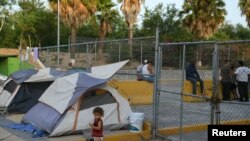 FILE - A 1-year-old Cuban asylum-seeker is seen in a makeshift migrant camp near the Gateway International Bridge in Matamoros, Tamaulipas, Mexico, June 29, 2019.