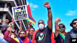 People protest in Port Louis, Mauritius, Aug. 29, 2020, over the government's slow response to an oil spill from a grounded Japanese ship and the alarming discovery of dozens of dead dolphins.