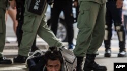 FILE - Riot police detain a man as they clear protesters taking part in a rally against a new national security law in Hong Kong on July 1, 2020.