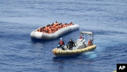 This undated image made available by the Italian Navy Marina Militare shows migrants being rescued at sea.