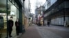 Shopkeepers wearing masks to prevent contracting the coronavirus wait for a customer at Dongseong-ro shopping street in central Daegu, South Korea, Feb. 21, 2020.