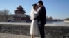 FILE - Groom Dong Yangfeng and bride Wang Sai pose for photos near the Forbidden City in Beijing on Dec. 20, 2020. 