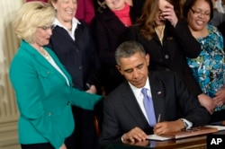 FILE - Lilly Ledbetter watches as President Barack Obama signs executive actions, with pending Senate legislation, aimed at closing a compensation gender gap that favors men, at the White House in Washington, April 8, 2014, during an event marking Equal Pay Day.