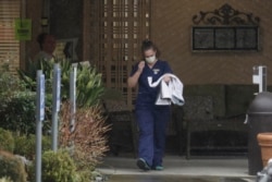 A worker at the Life Care Center in Kirkland, Wash., near Seattle, wears a mask as she leaves the building, March 2, 2020.