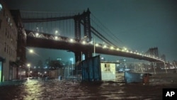 Banjir menggenangi jalanan di bawah Jembatan Manhattan di kota New York akibat badai Sandy. (AP/Bebeto Matthews)