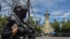 An Indonesian policeman stands guard outside a church after an explosion in Makassar, March 28, 2021.
