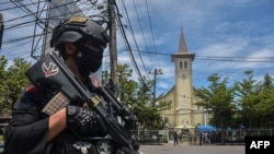 An Indonesian policeman stands guard outside a church after an explosion in Makassar, March 28, 2021.