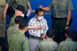 Former pro-democracy lawmaker Albert Ho is escorted by Correctional Services officers to a prison van for a court in Hong Kong, May 28, 2021.