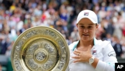 Australia's Ashleigh Barty poses with the trophy after winning the women's singles final, defeating the Czech Republic's Karolina Pliskova on day 12 of the Wimbledon Tennis Championships in London, July 10, 2021. 