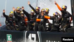 Oracle Team USA waves after defeating Emirates Team New Zealand during Race 16 of the 34th America's Cup, Sept. 23, 2013.