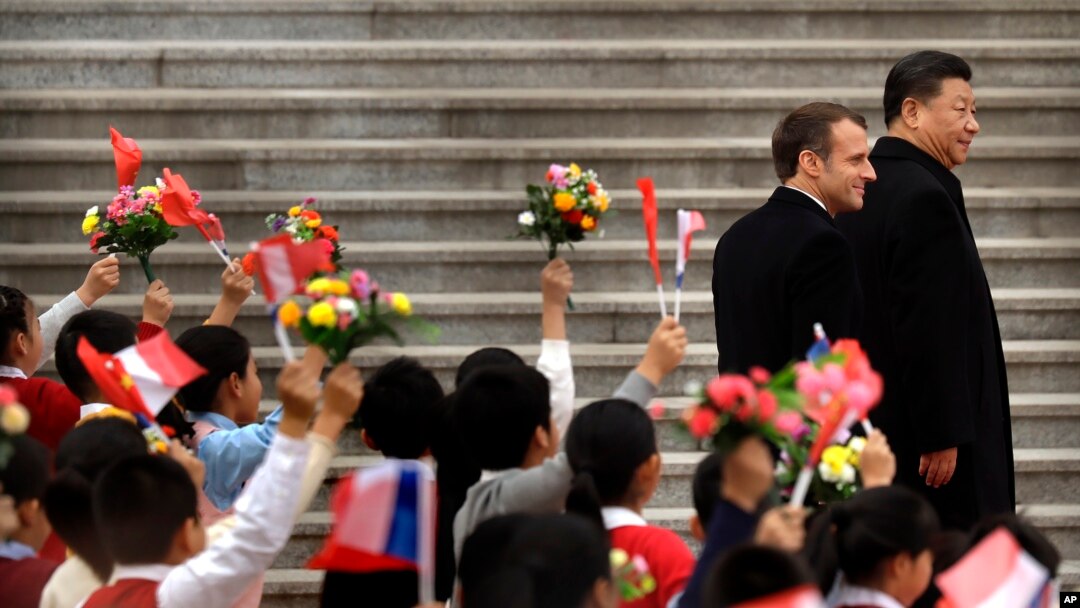 Presiden Perancis Emmanuel Macron (kiri) dan Presiden China Xi Jinping disambut anak-anak yang membawa bendera Perancis dan China di Aula Agung Rakyat di Beijing, 6 November 2019.