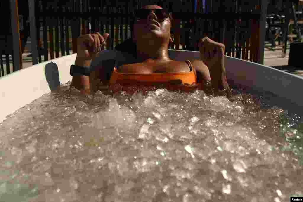 A woman takes an ice bath during a heat wave at Ipanema Beach in Rio de Janeiro, Brazil.