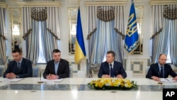 Dari kiri ke kanan: Vitali Klitschko, Oleg Tjagnibok, Presiden Ukraina Viktor Yanukovych, dan pemimpin oposisi, Arseniy Yatsenyuk, saat penandatanganan kesepatan di Kiev, Ukraina (21/2). 