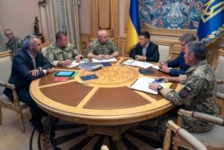FILE - Ukrainian President Volodymyr Zelenskiy, third right, attends a meeting with Ukrainian top military officials in Kyiv, Ukraine, Aug. 7, 2019. (Ukrainian Presidential Press Office via AP)