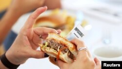 Journalists taste test the plant-based hamburgers during a media tour of Impossible Foods labs and processing plant in Redwood City, California, U.S. October 6, 2016. REUTERS/Beck Diefenbach/File Phot